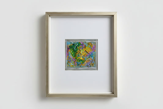 A custom framed artwork featuring a colorful, abstract scene, part of the Whimsy in Wonderland series, displayed on a wooden surface with a reflective background.