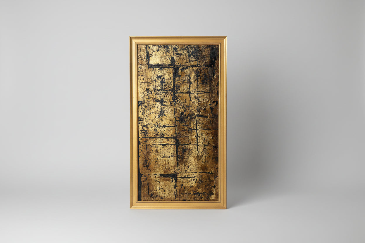 A canvas painting with a gold frame, displaying a textured gold surface, placed on a wooden surface with a mannequin head in the background.