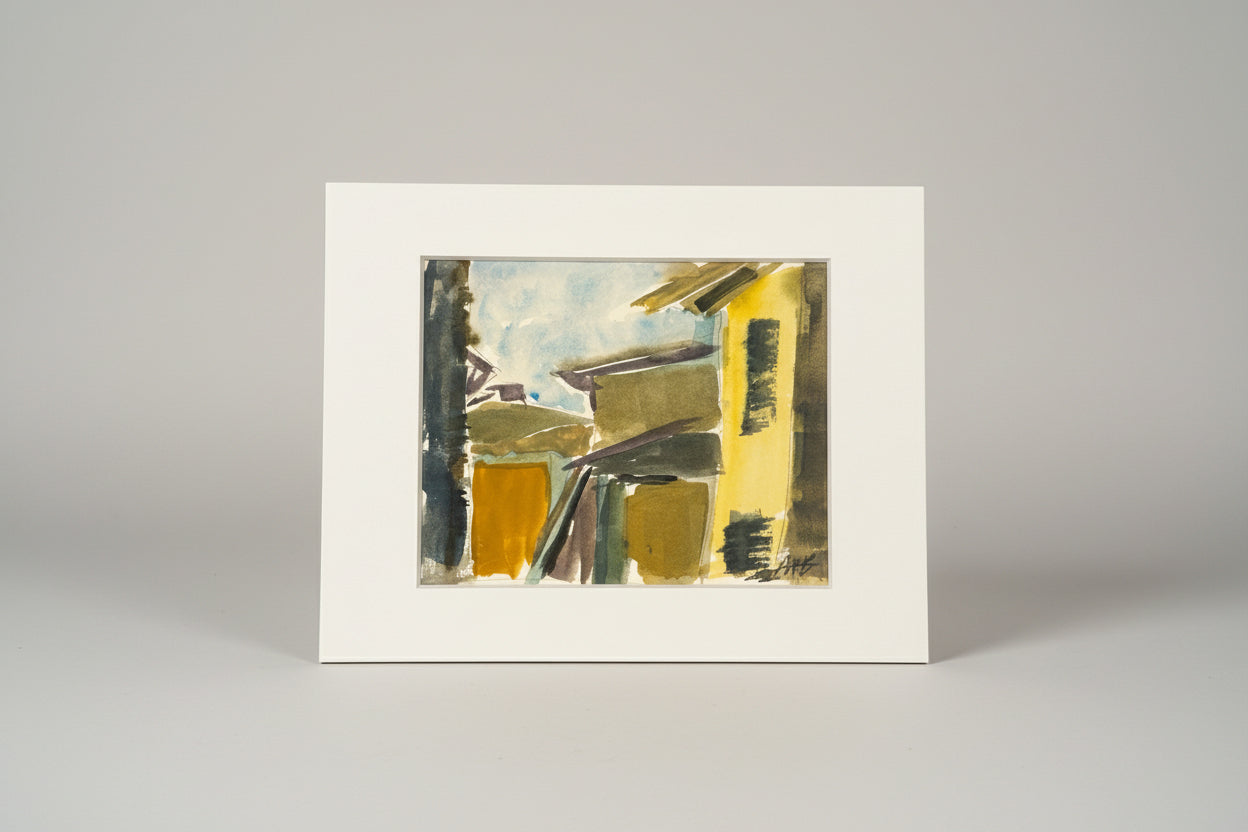 A framed abstract mixed media artwork on paper titled 'Town View', displayed on a wooden surface with a window in the background.