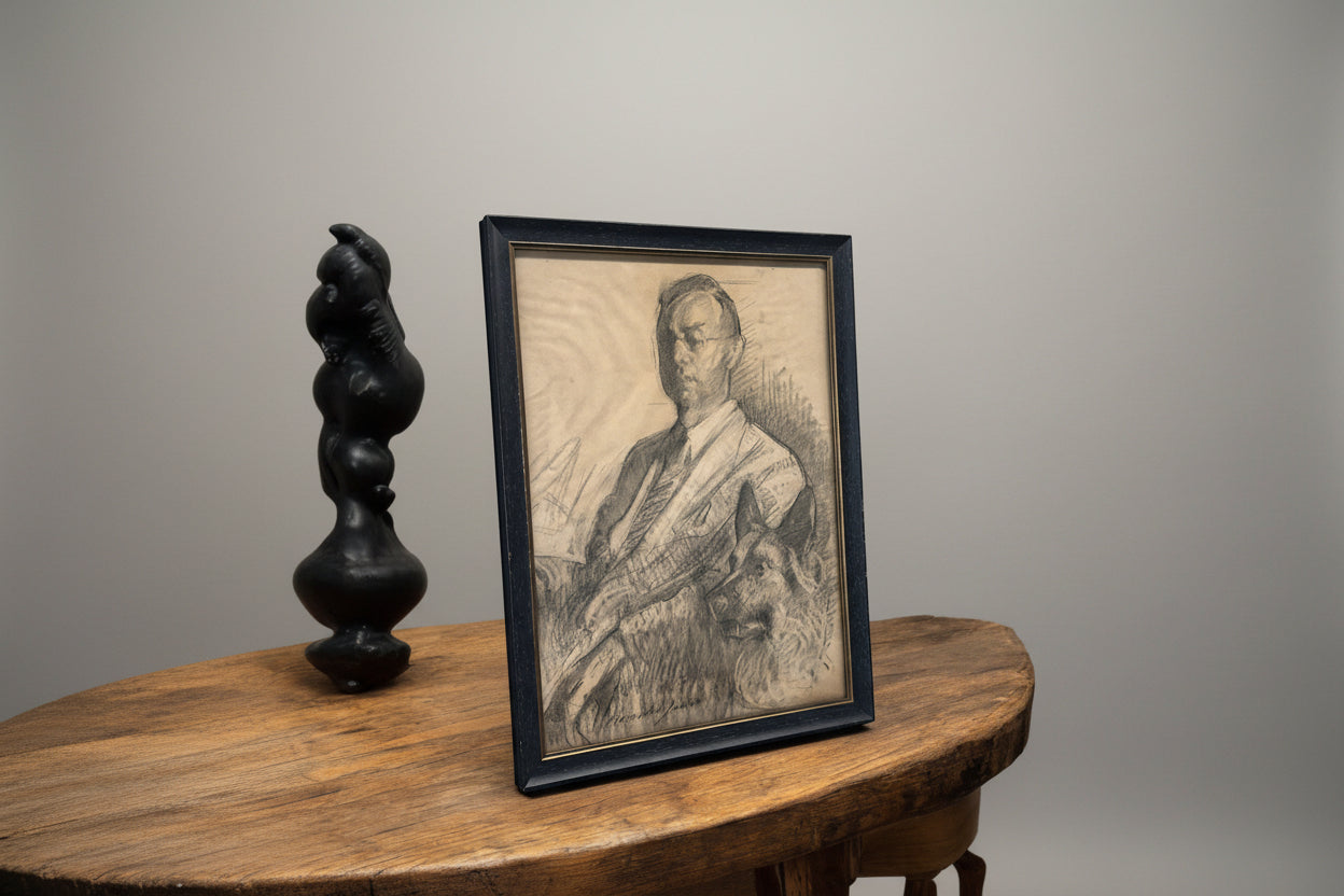 Antique pencil drawing of a president with their dog, framed and placed on a wooden table.