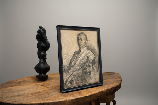 Antique pencil drawing of a president with their dog, framed and placed on a wooden table.