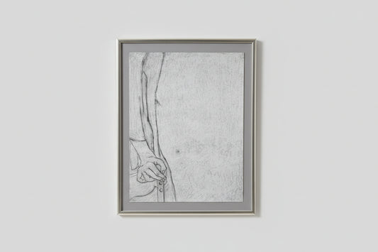 A framed lithograph drawing, depicting a figure with a contemplative expression, displayed on a wall above a wooden table with two black sculptures beside it.