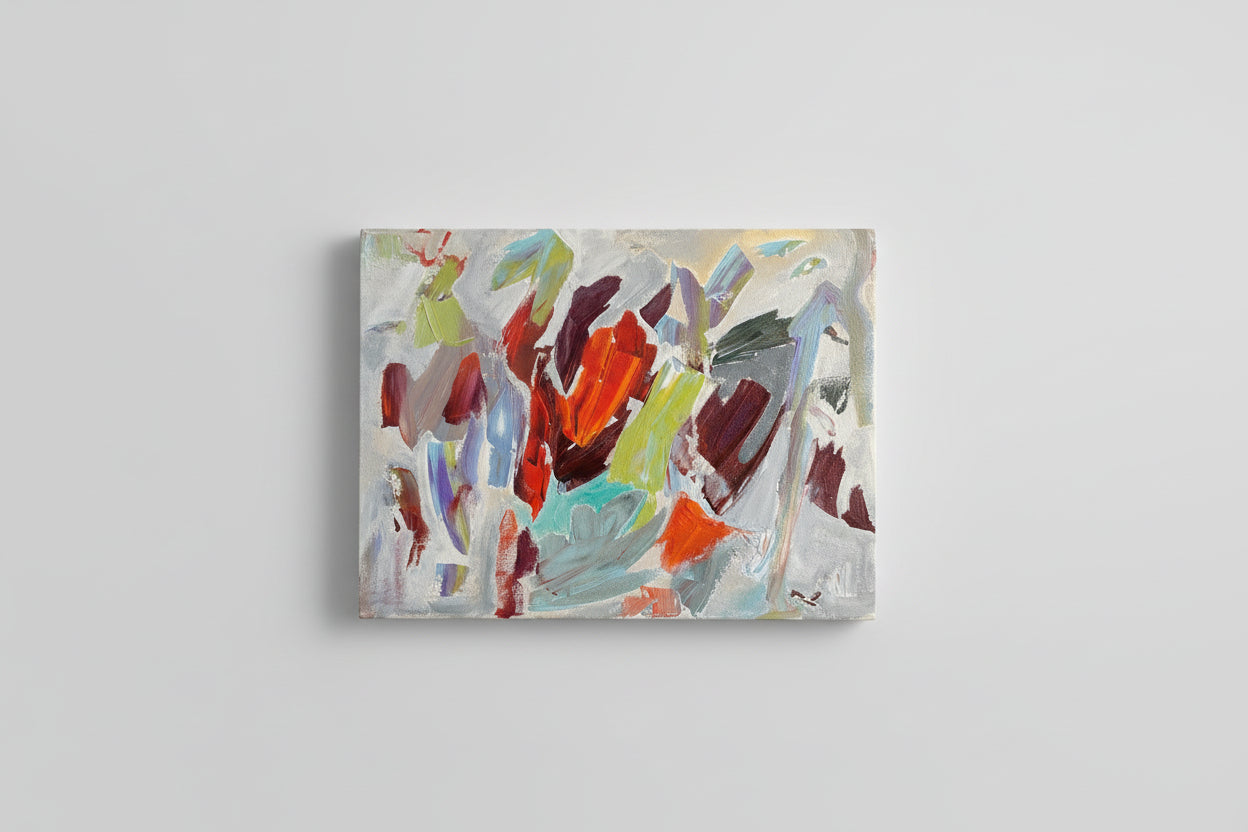 An abstract oil painting on canvas, featuring a blend of colors in a geometric pattern, placed on a wooden surface with a shadow falling over it.