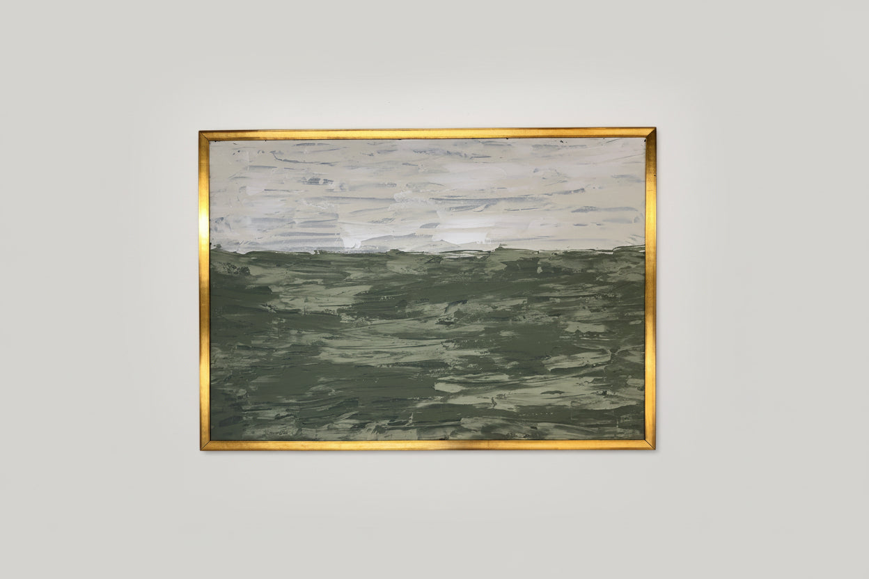 An acrylic on board artwork depicting a green landscape, framed in a gold custom frame, displayed on a wall above a green mossy object.