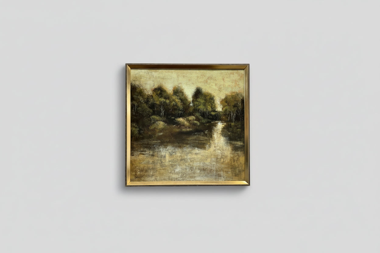 A framed oil painting on wood, depicting a lakeside scene, professionally hung on a wall.