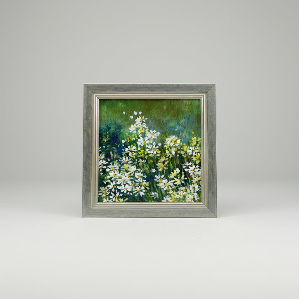An acrylic painting of daisies in a frame, displayed on a wall.