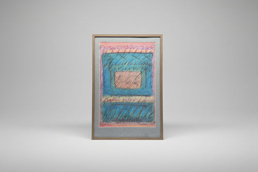 A framed mixed media artwork by Denise Freda, featuring geometric patterns with pink, blue, green, and beige colors, displayed on a table beside a plant.
