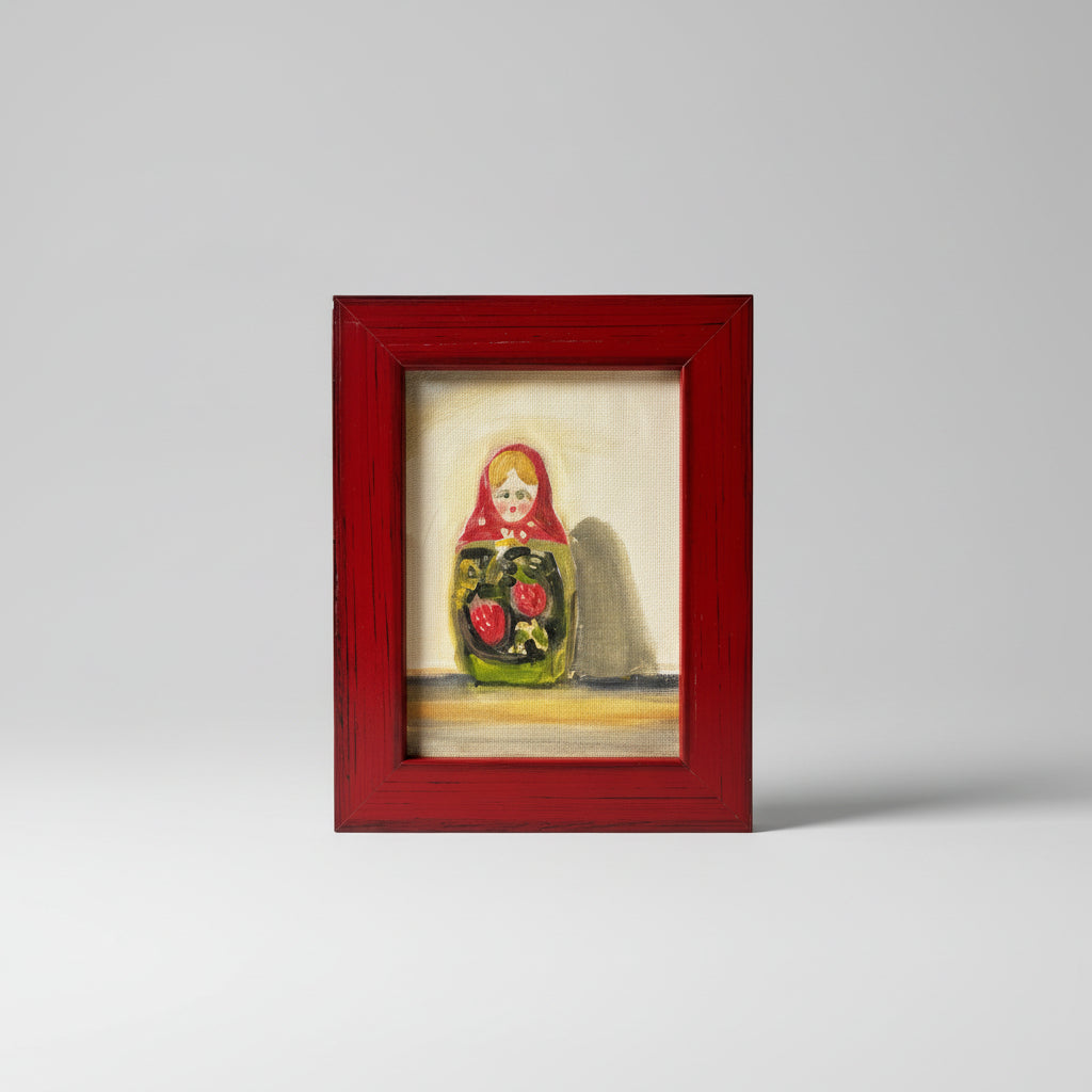 A framed oil painting on board depicting a colorful character, displayed on a dark surface against a neutral wall.