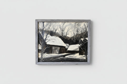 An oil on wood painting depicting a winter scene with barns, framed in a barnwood frame, displayed on an interior wall.