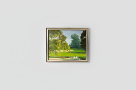 An oil on board artwork depicting a park scene, framed in a silver frame, displayed on a wall.