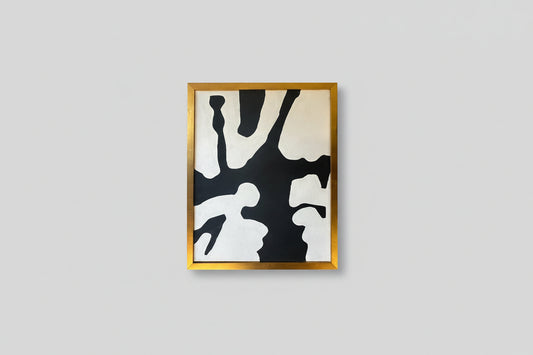 An abstract artwork with black and white lines, framed in a gold frame, displayed on a wall in a well-lit room with a bench in the foreground.