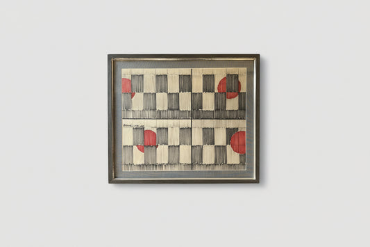 Framed pen and ink artwork with a geometric checkerboard pattern featuring red and black colors on a white background, displayed on a wall.