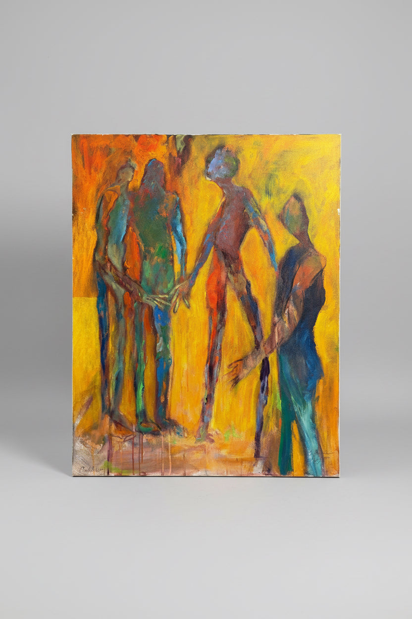 An expressive oil painting on canvas depicting four stylized human figures holding hands, set against a vibrant yellow and orange background. The painting is displayed leaning against a beige desk or cabinet on a patterned rug.