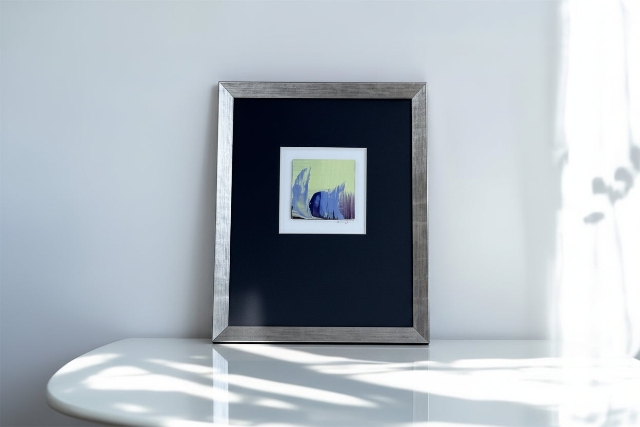 Framed artwork on a white surface with colorful glass balls